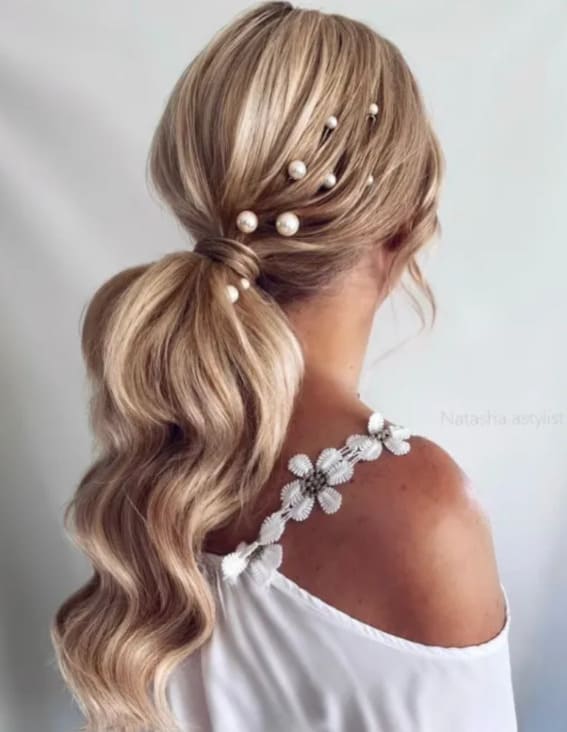 A lady who wears a romantic low ponytail with pearls is the perfect choice to be a wedding guest.